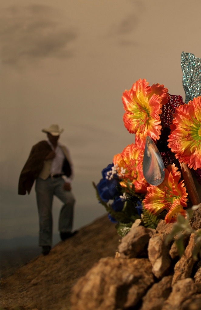 Cowboy and flowers on grave © 